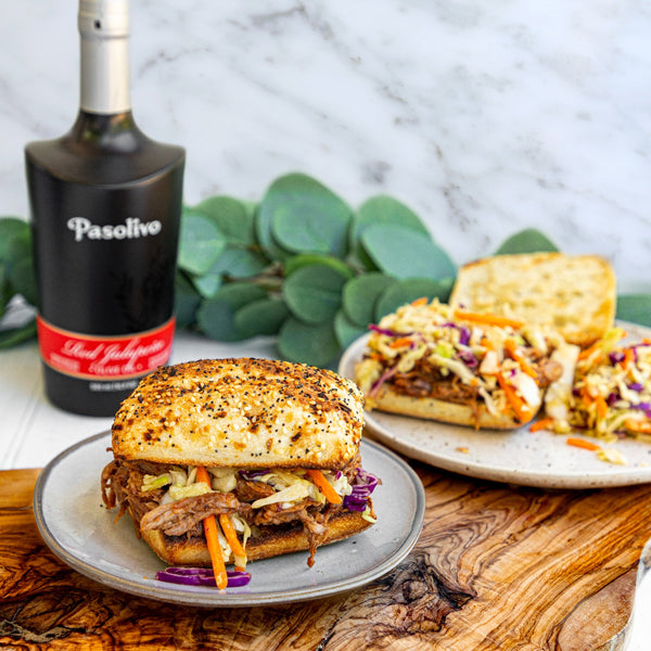 Pasolivo Red Jalapeno Pulled Pork Sandwich Recipe on table next to Pasolivo Red Jalapeno Olive Oil