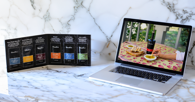 Laptop displaying a video call with a person sitting at a table outdoors, next to a brochure of tea packages on a marble surface.