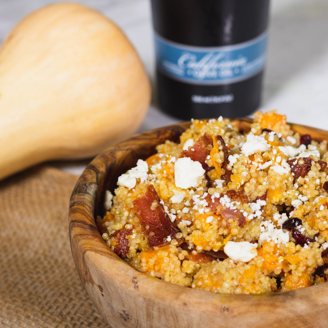Harvest Quinoa Salad Recipe in a bowl on kitchen counter with Pasolivo California Olive Oil and squash